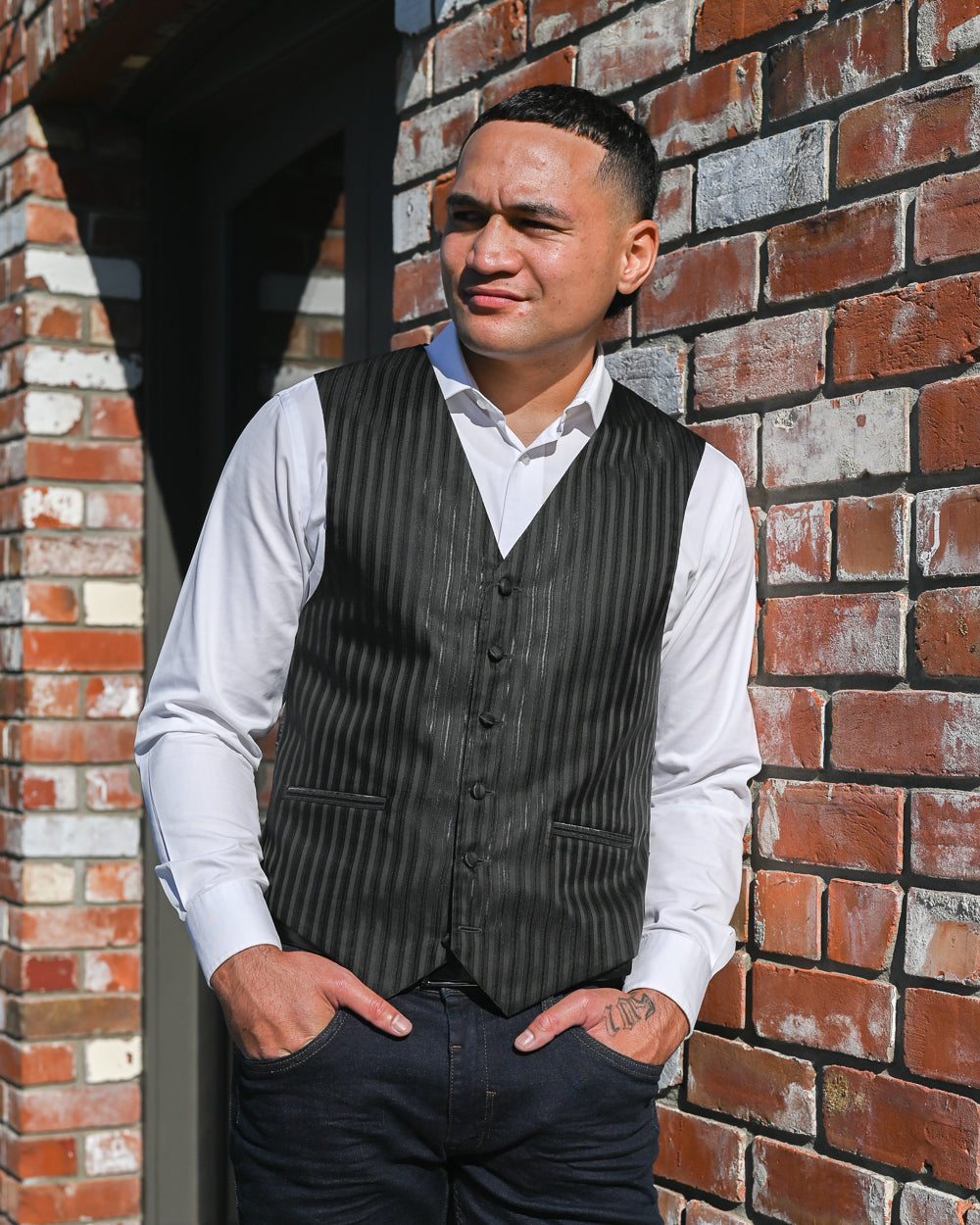 Handsome young man wearing a black stripe waistcoat with a white shirt