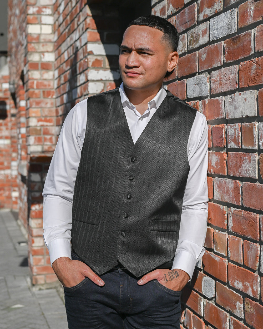 Handsome young Samoan man wearing a dark grey stripe waistcoat with a white shirt
