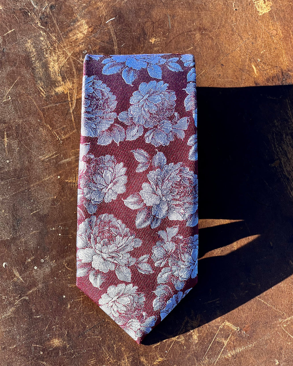 Pure silk tie featuring white roses against burgundy ground