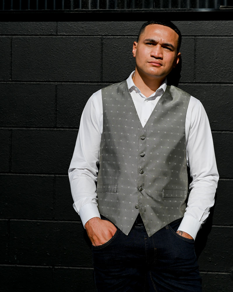 Handsome young man wearing a grey waistcoat with a white shirt