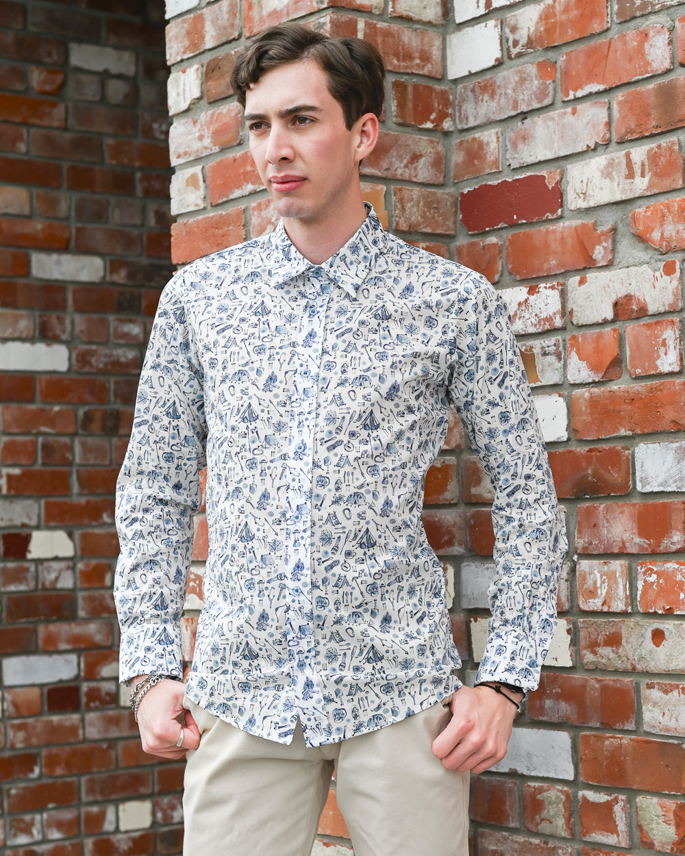 Man wearing a long-sleeve cotton shirt which has a small camping print on it. Mr Peacock made in NZ