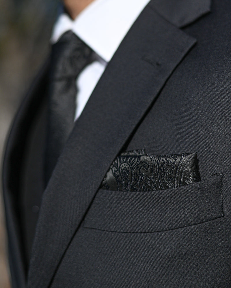 Black paisley pocket square worn with a black suit