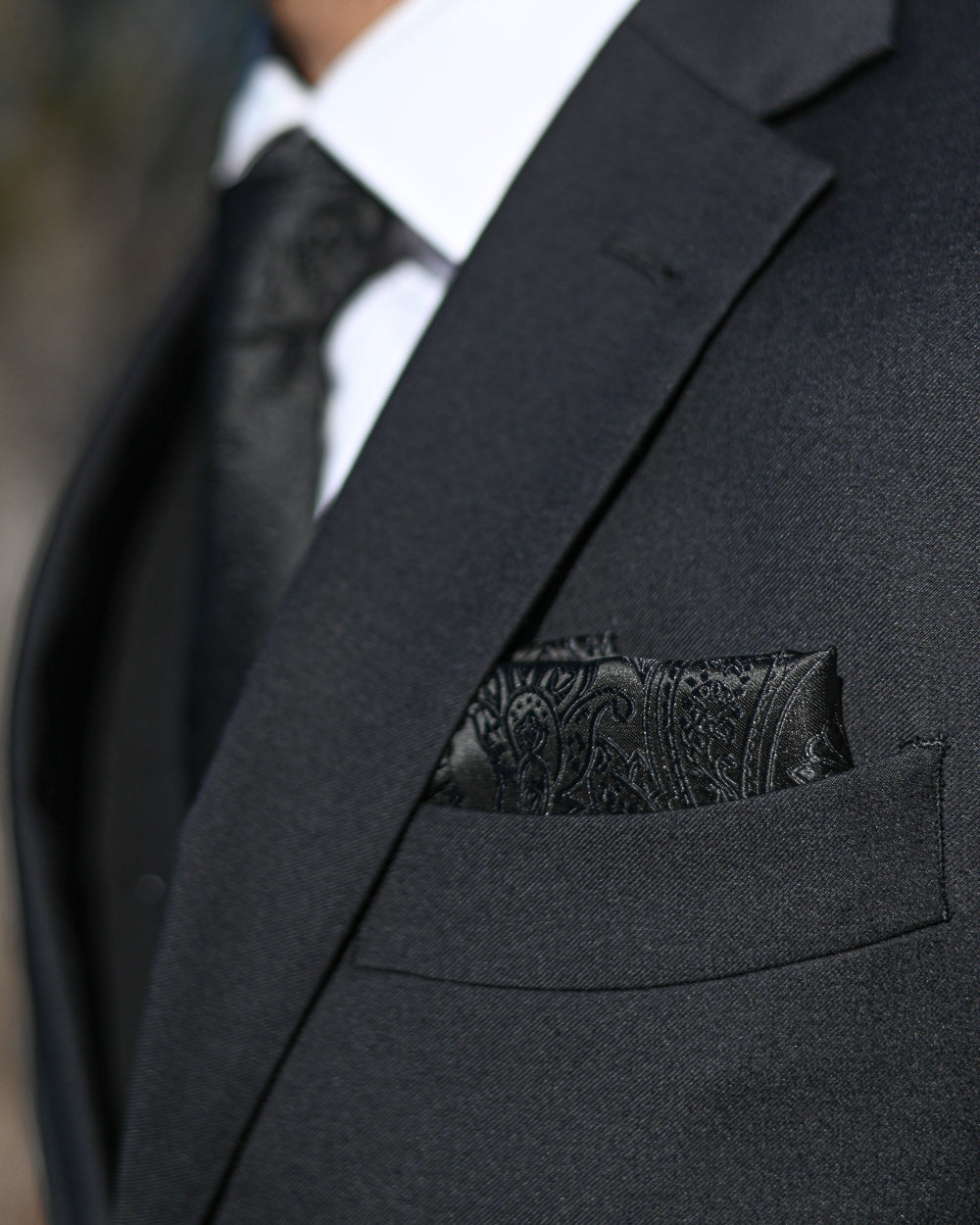 Black paisley pocket square worn with black suit