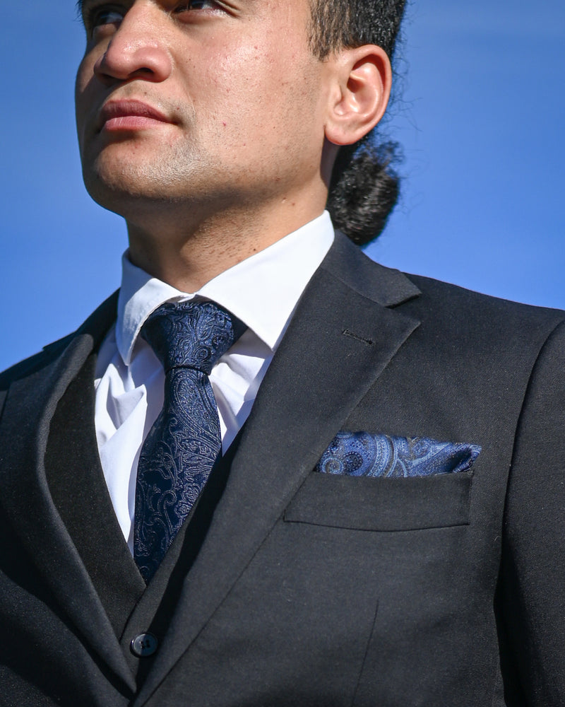 Blue paisley tie worn with matching pocket square and a black suit