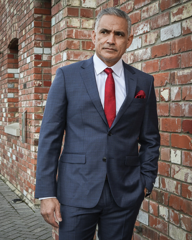 Distinguished man wearing a pure wool suit by Boston with a red tie and red pocket square