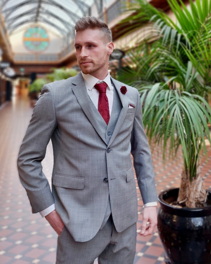 Young blonde man wearing grey three piece suit by Savile Row