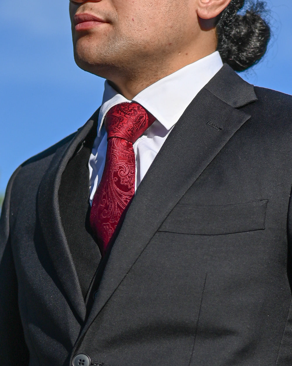 Crimson red paisley tie worn with 3-piece black suit