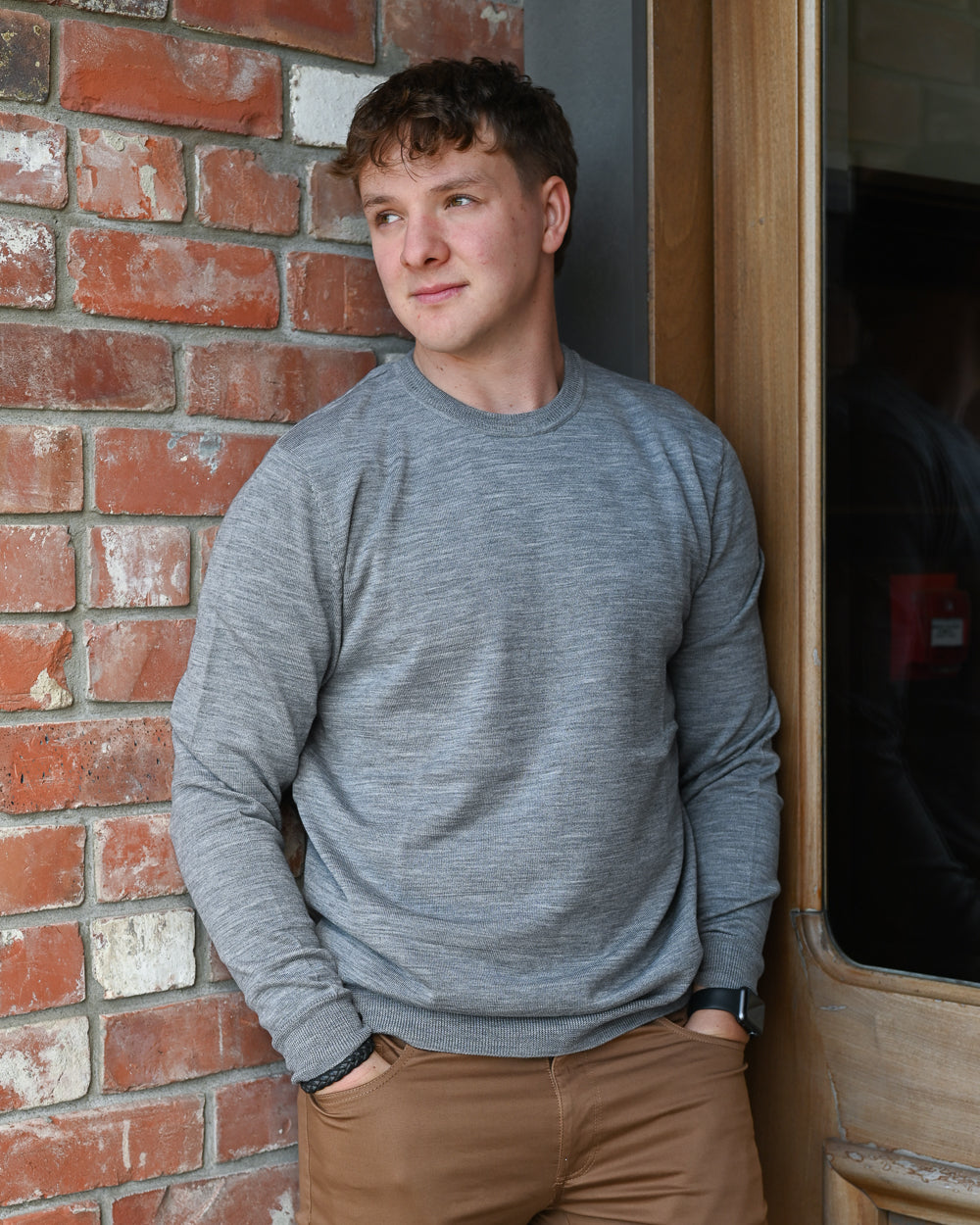 Young man wearing a grey super-fine merino crew-neck pullover