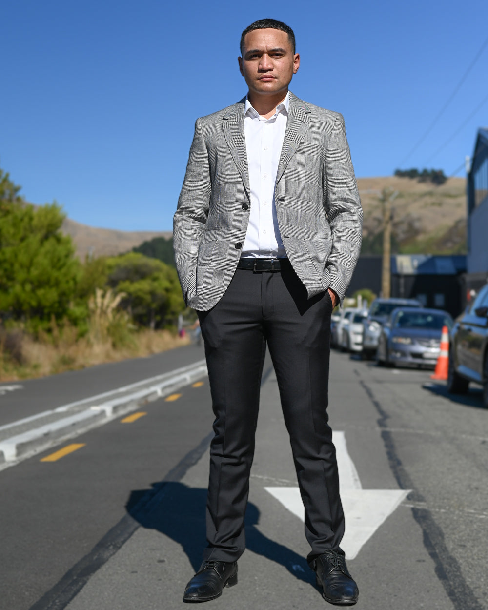 Young man standing in road wearing grey check blazer by Daniel Hechter
