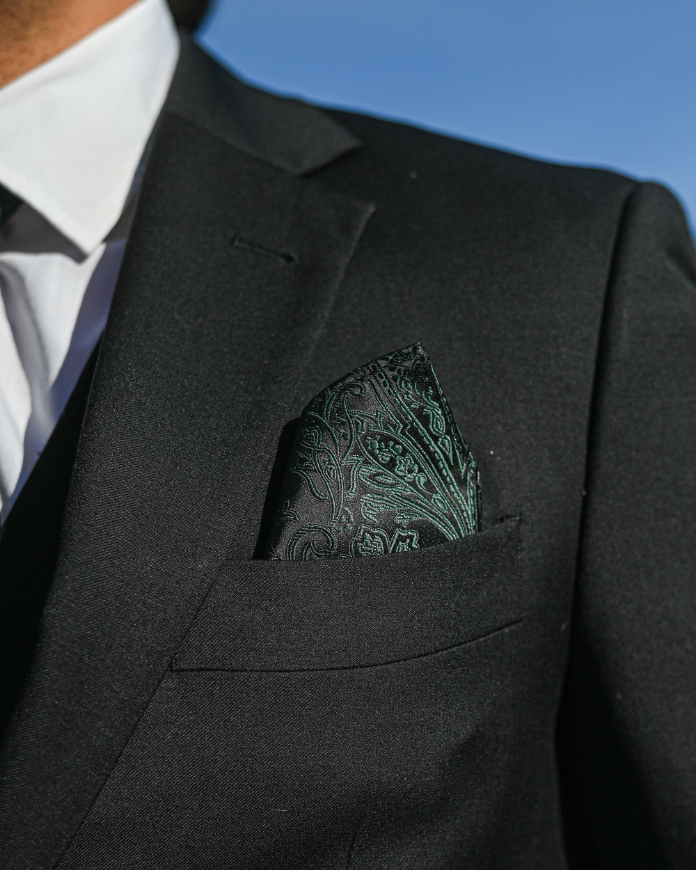 Green paisley pocket square worn with a black suit