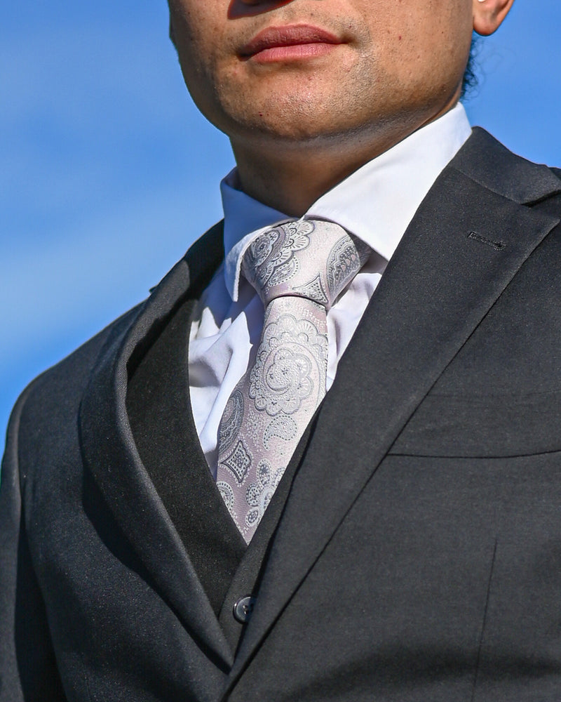 Pale pink paisley tie worn with a black suit