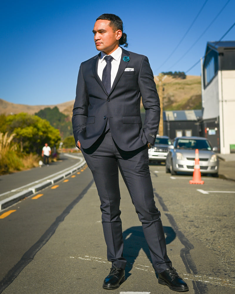 Handsome young man wearing a dark navy suit by Savile Row