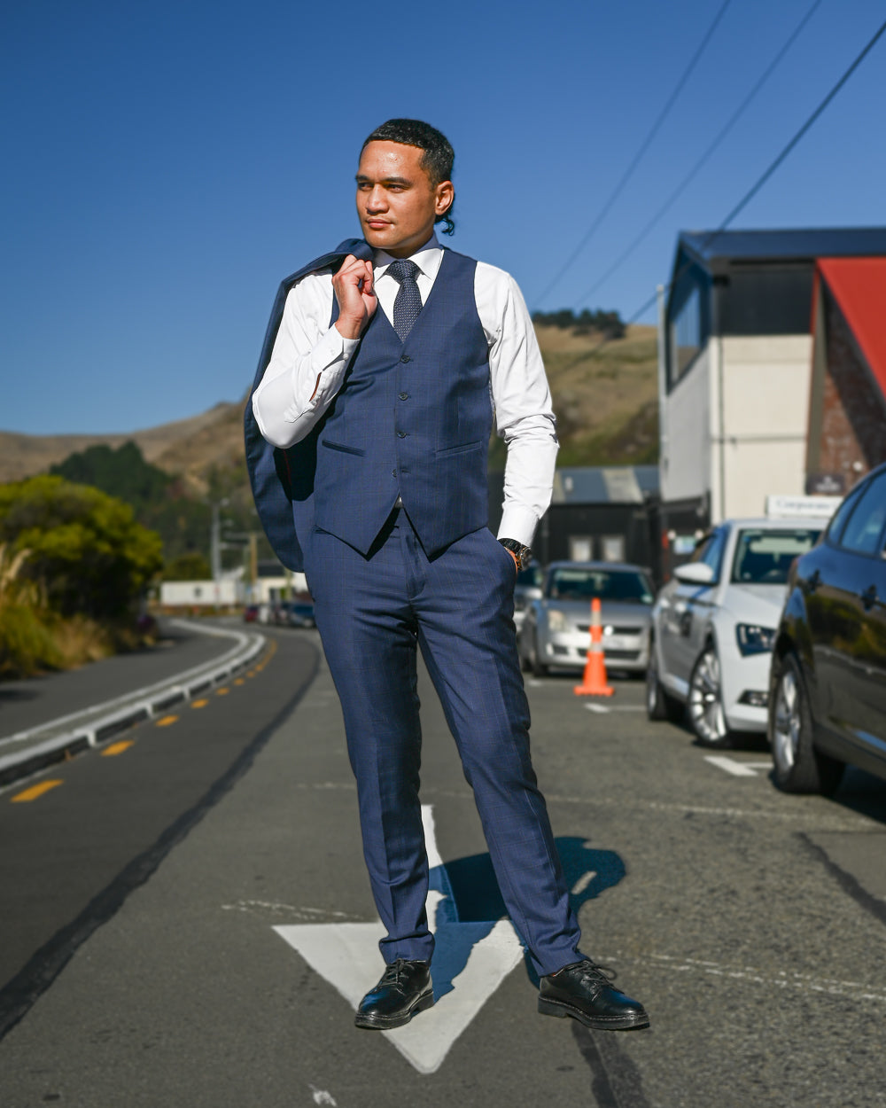 Handsome young man in a navy suit waistcoat by Savile Row