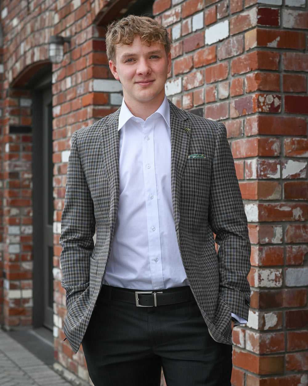 Young man wearing tweed sports coat by Savil Row with white shirt