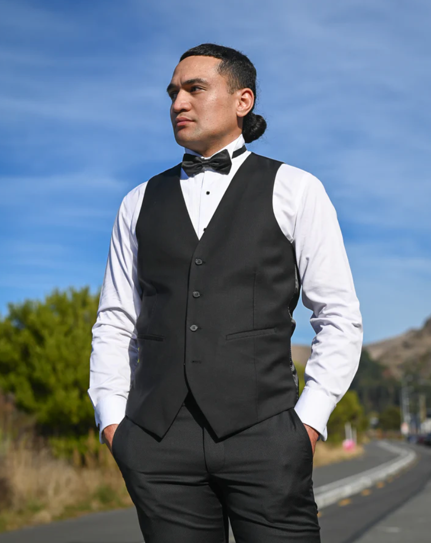 Handsome young man in black waistcoat, white shirt and black bow tie