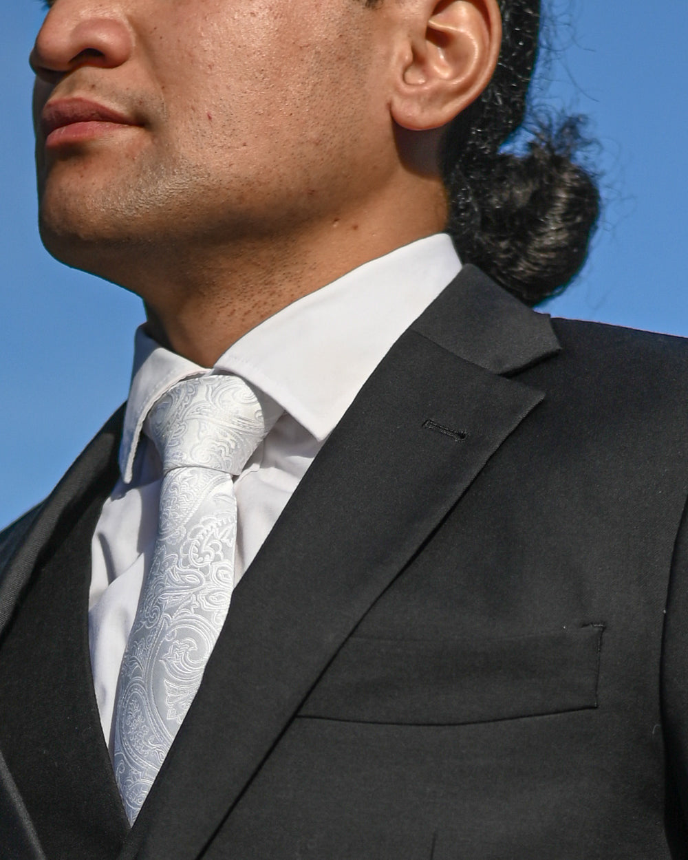 White paisley tie worn with black three-piece suit