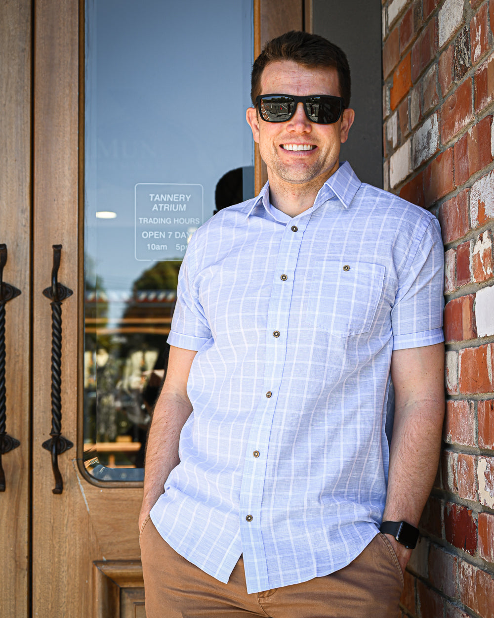 Man wearing pale blue and white check shirt with short-sleeves