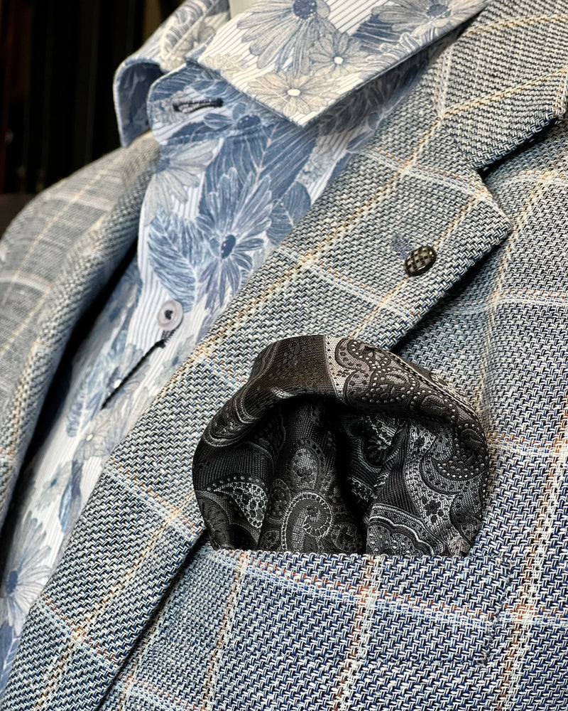 Black and grey paisley pocket square in pocket of check jacket