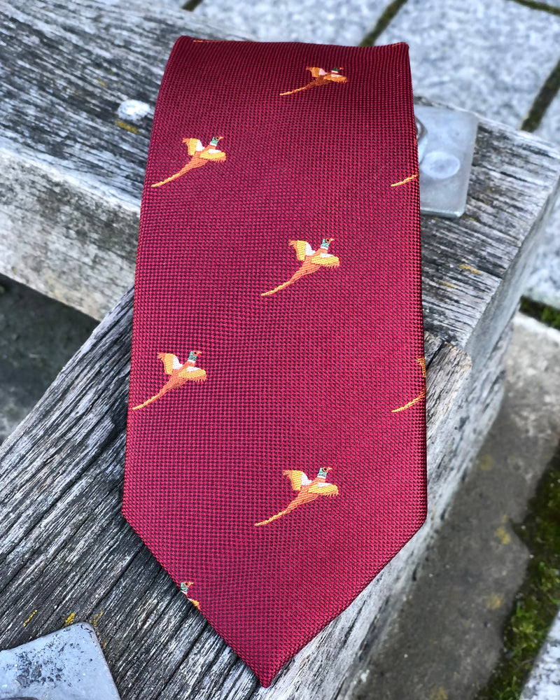 A pure silk tie featuring golden pheasants against a crimson ground