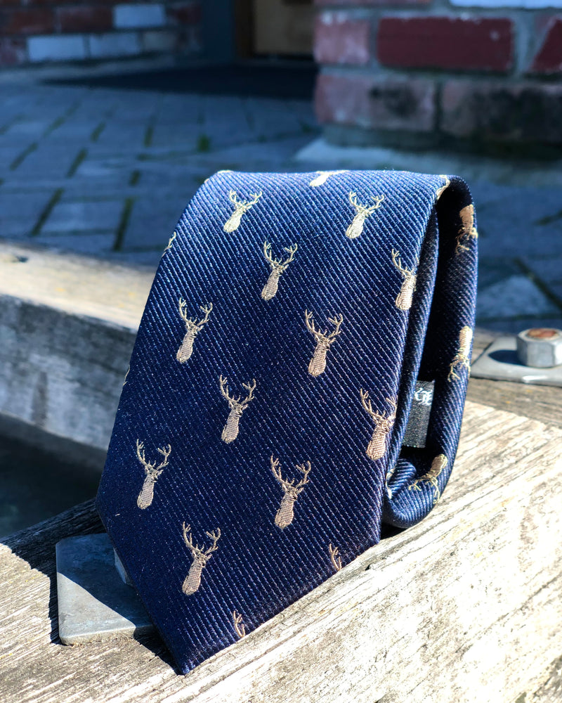 Pure silk tie featuring stag heads against a dark blue background