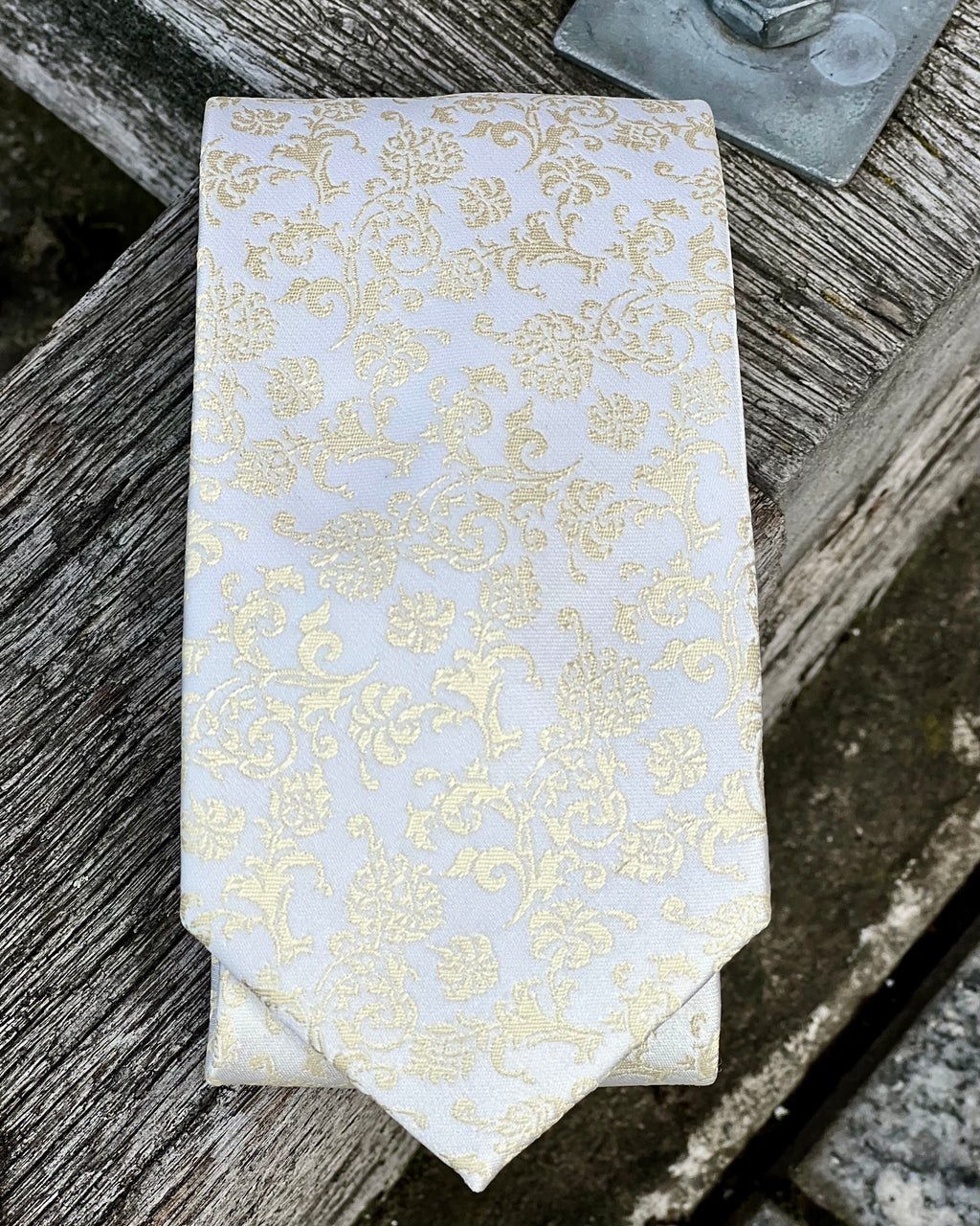 White tie with gold pattern by the tie company