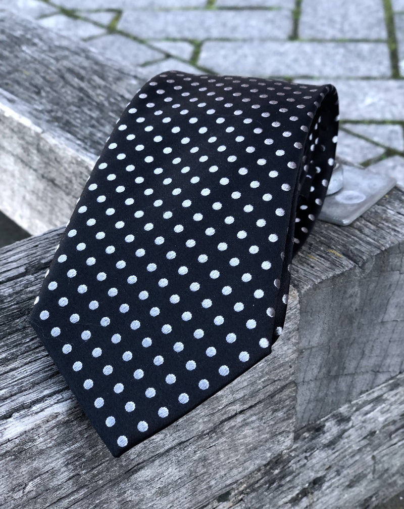 Pure silk tie featuring white dots against a dark background